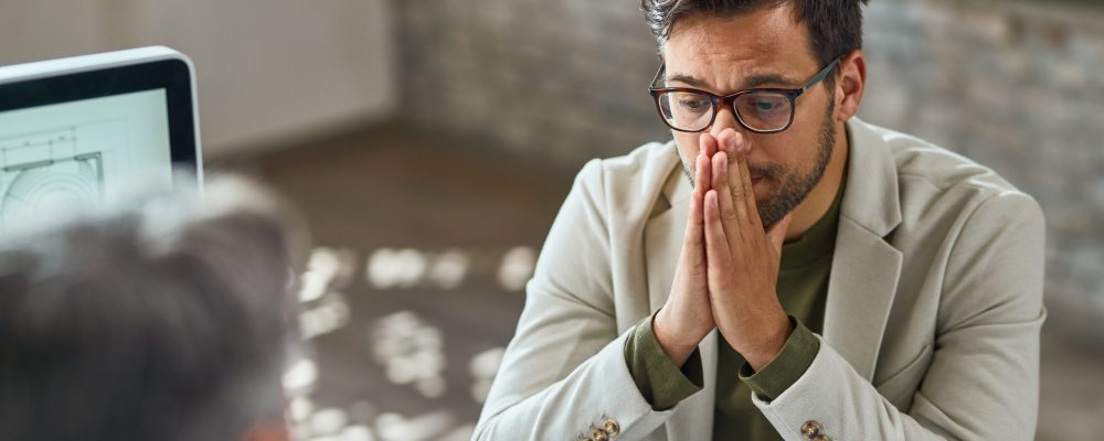 Distraught young man feeling uncertain while having a job interview in the office.